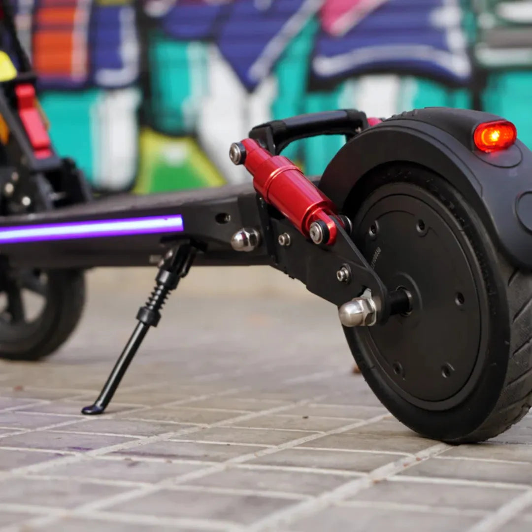 Detalj stražnjeg crvenog amortizera električnog romobila Joyor G5 s upaljenim stražnjim svjetlom
