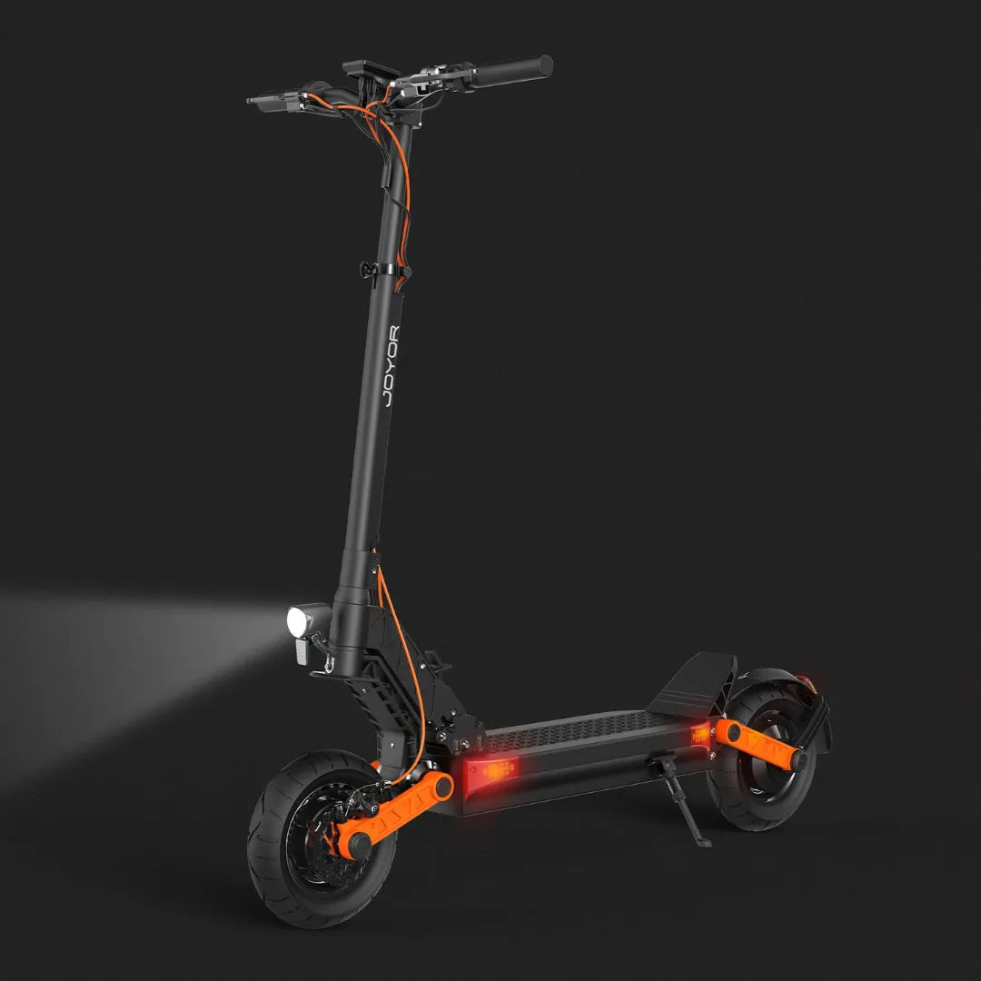 Električni romobil Joyor S10-S crne boje s narančastim detaljima i upaljenim svjetlima bočni pogled