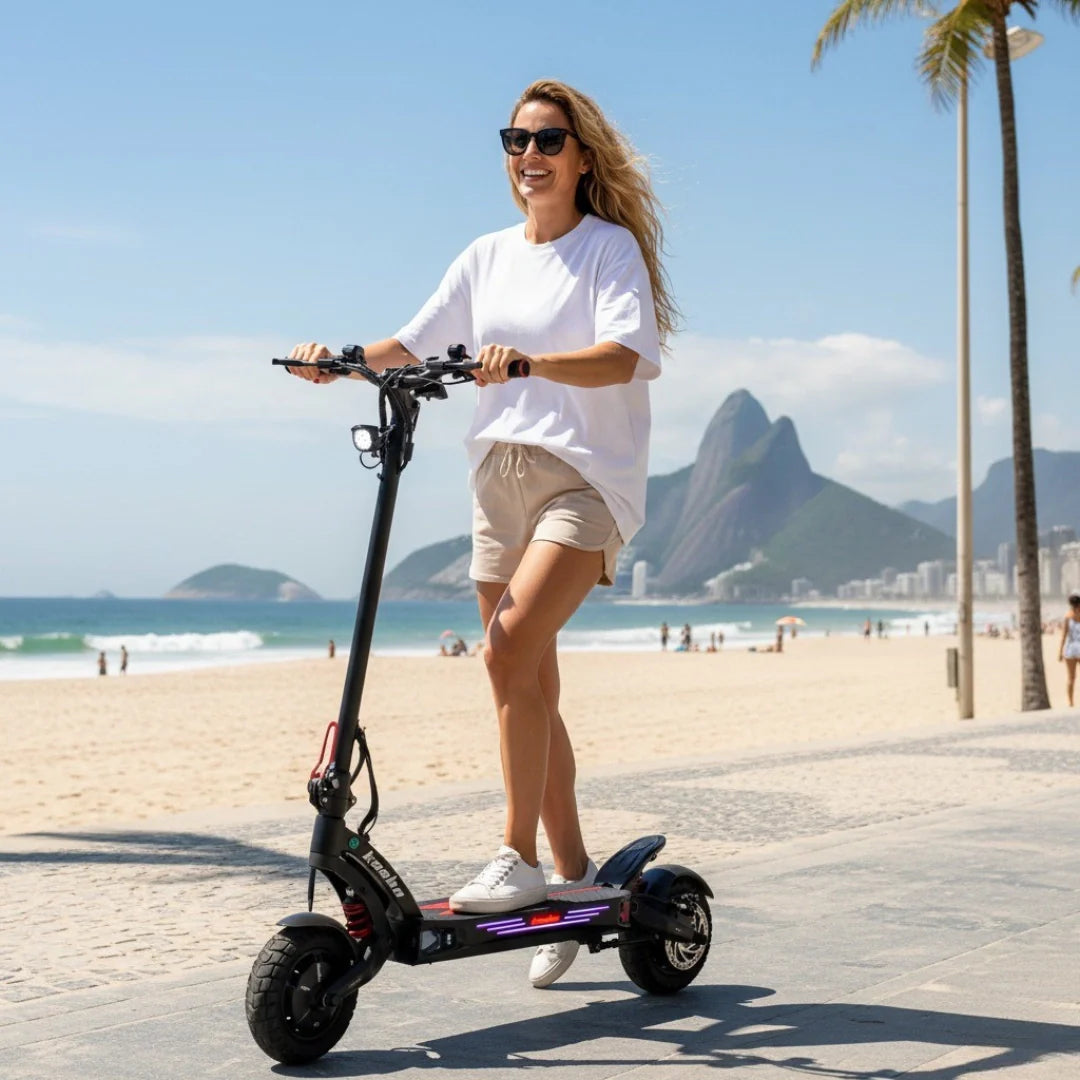 Žena se vozi na crnom električnom romobilu Kaabo Mantis King GT uz plažu na sunčan dan