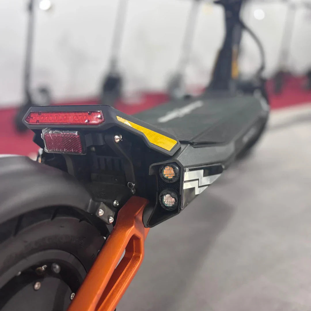 Stražnji dio električnog romobila MS Energy Flare X Pro s crvenim svjetlom i narančastim detaljima