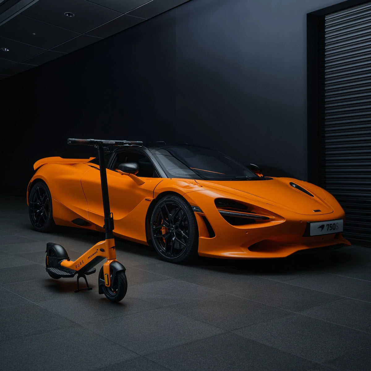 Narančasti električni romobil Pure Advance McLaren edition ispred sportskog automobila McLaren 750S