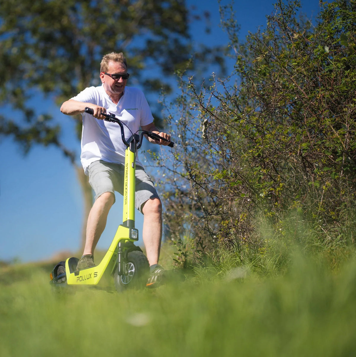 Muškarac vozi električni romobil Streetbooster Pollux Sa svijetlo zelene boje u prirodi