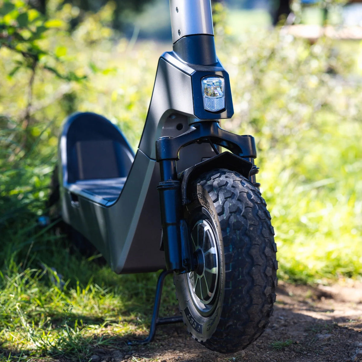 Prednji dio crnog električnog romobila Streetbooster Castor s terenskom gumom i svjetlom