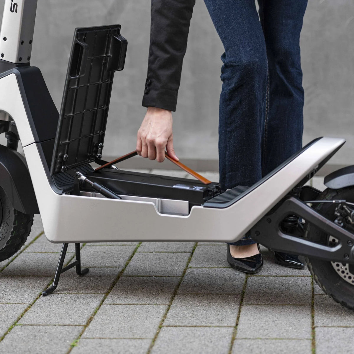 Vađenje prenosive baterije iz električnog romobila Streetbooster Pollux bijele boje
