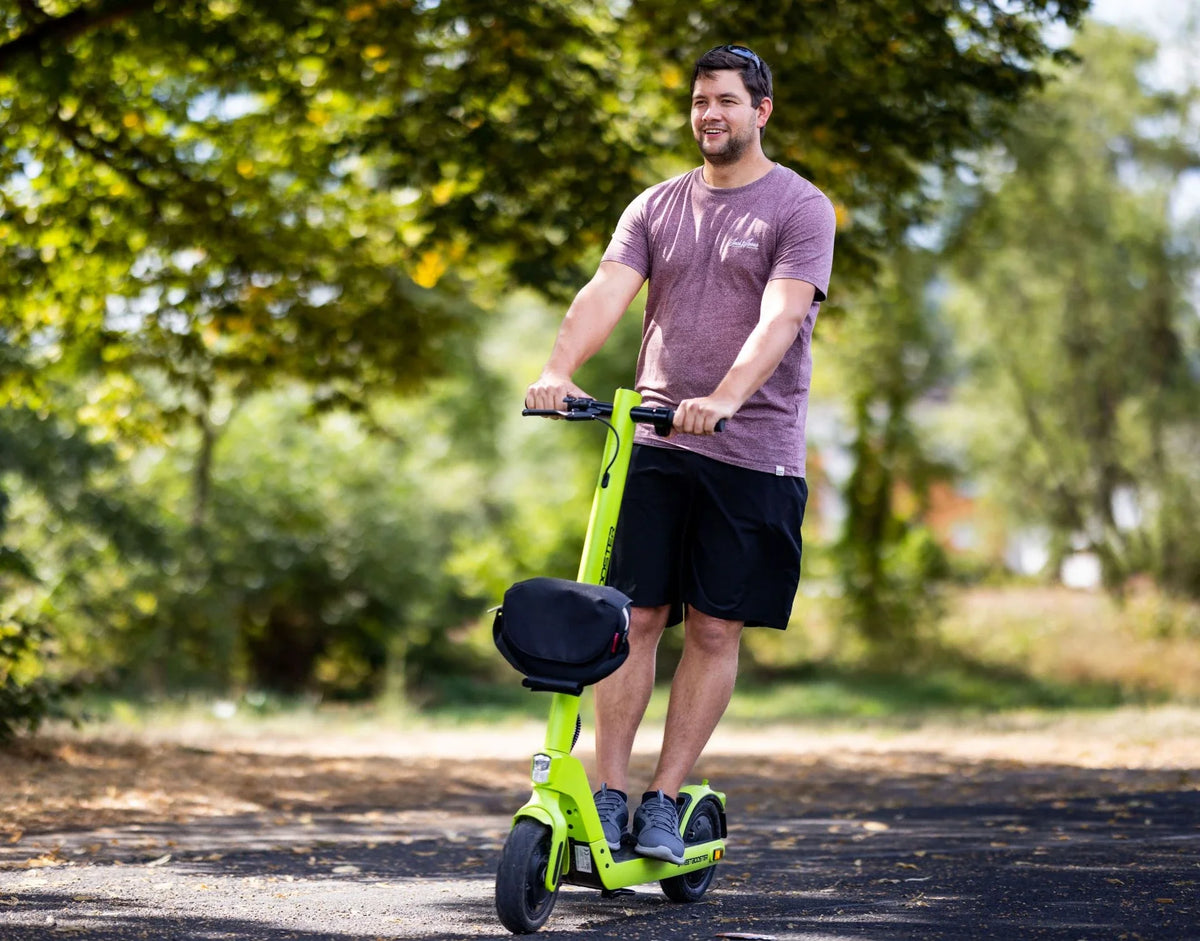Muškarac vozi svijetlozeleni električni romobil Streetbooster Sirius na otvorenom