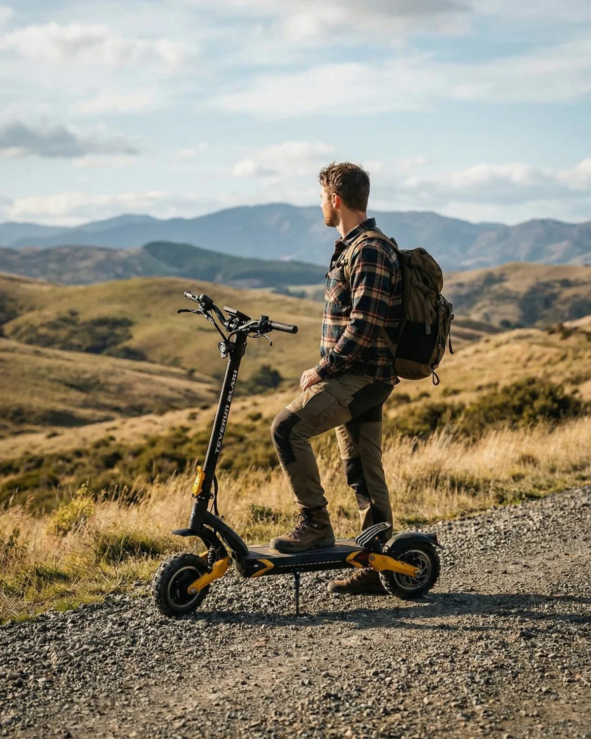 Muškarac s ruksakom na električnom romobilu Teverun Blade Mini Ultra u prirodi, bočni pogled