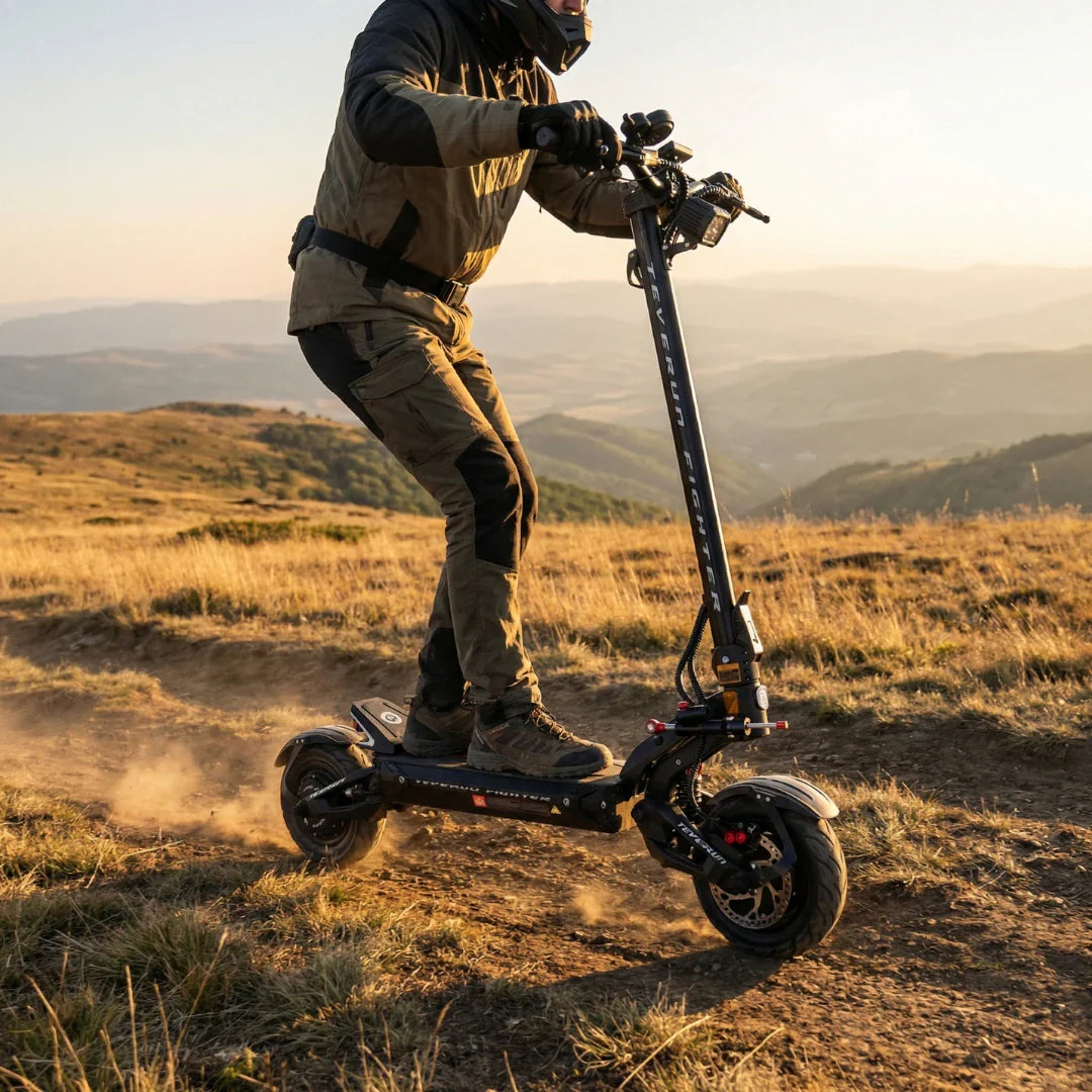 Električni romobil Teverun Fighter 11 u vožnji po makadamskoj stazi pri zalasku sunca