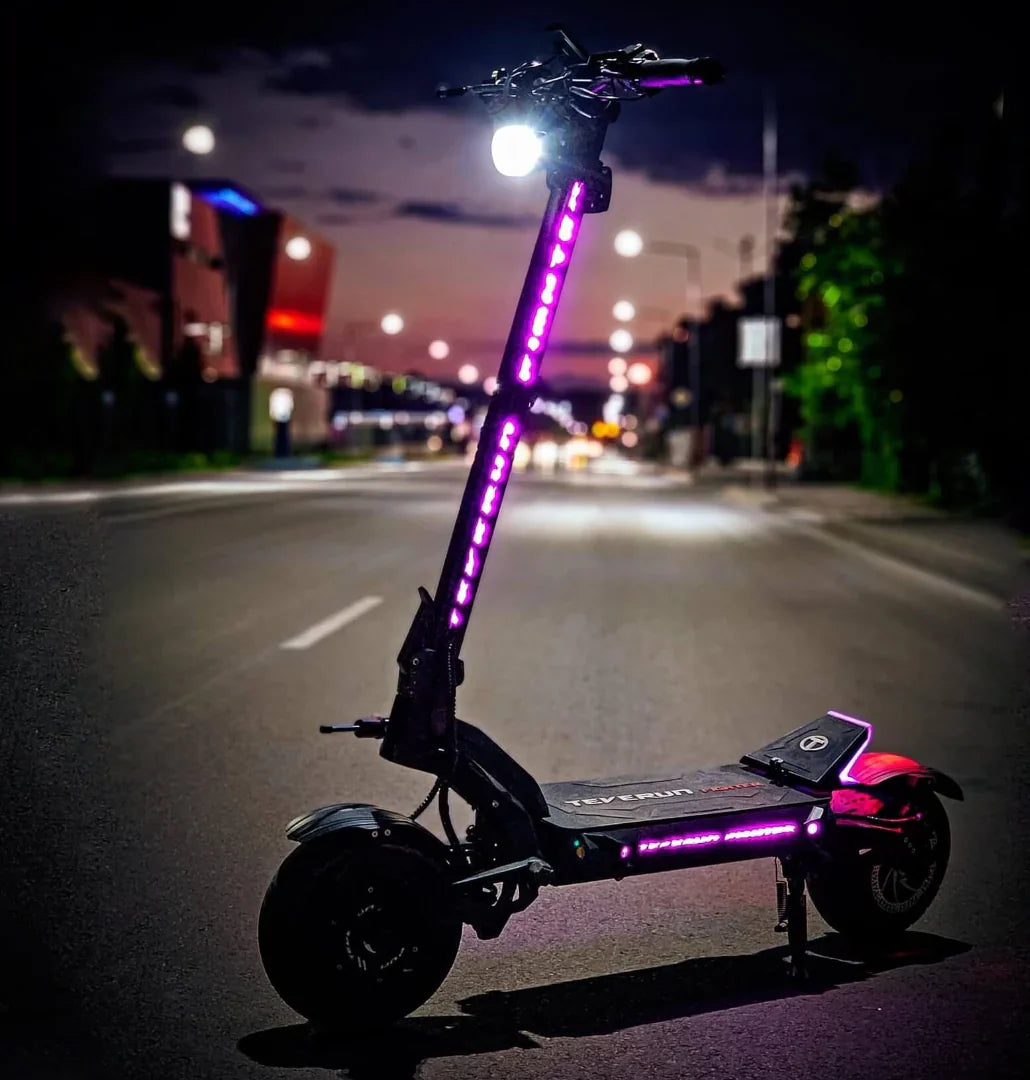 Električni romobil Teverun Fighter 11 Plus 2024 s ljubičastim LED osvjetljenjem noću na cesti