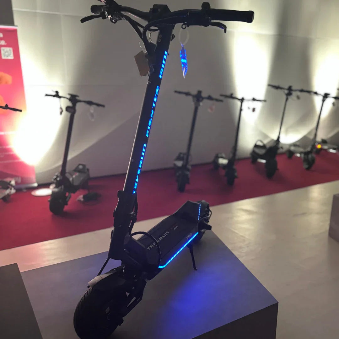 Električni romobil Teverun Fighter Mini Pro 2025 s plavim LED osvjetljenjem na postolju u salonu