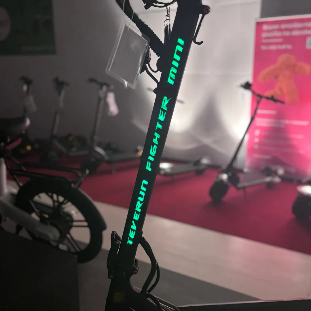 Krupni plan svijetlećeg logotipa na stupu upravljača električnog romobila Teverun Fighter Mini Pro