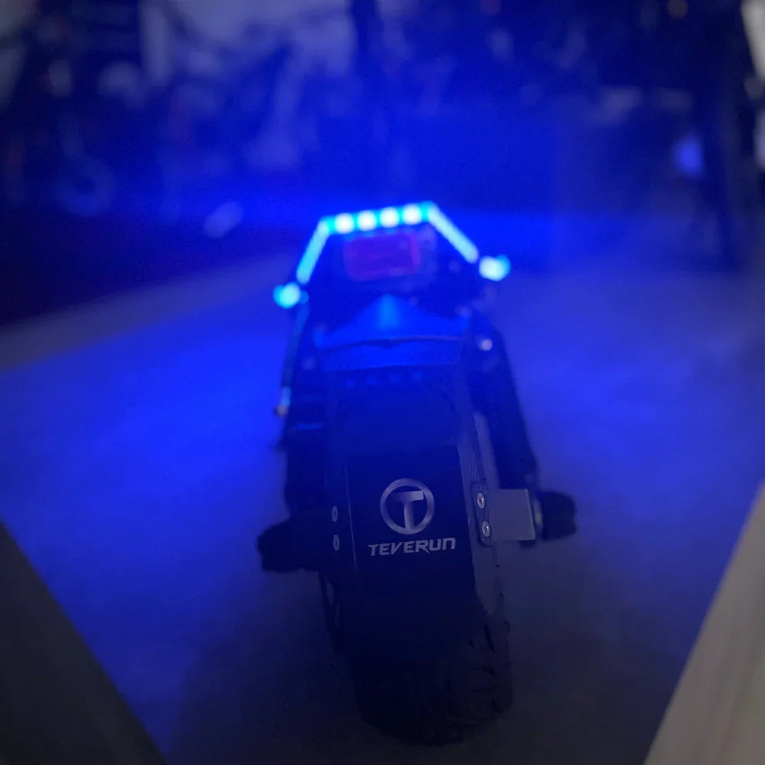 Stražnji pogled na električni romobil Teverun Fighter Mini Pro 2025 s upaljenim plavim LED svjetlima