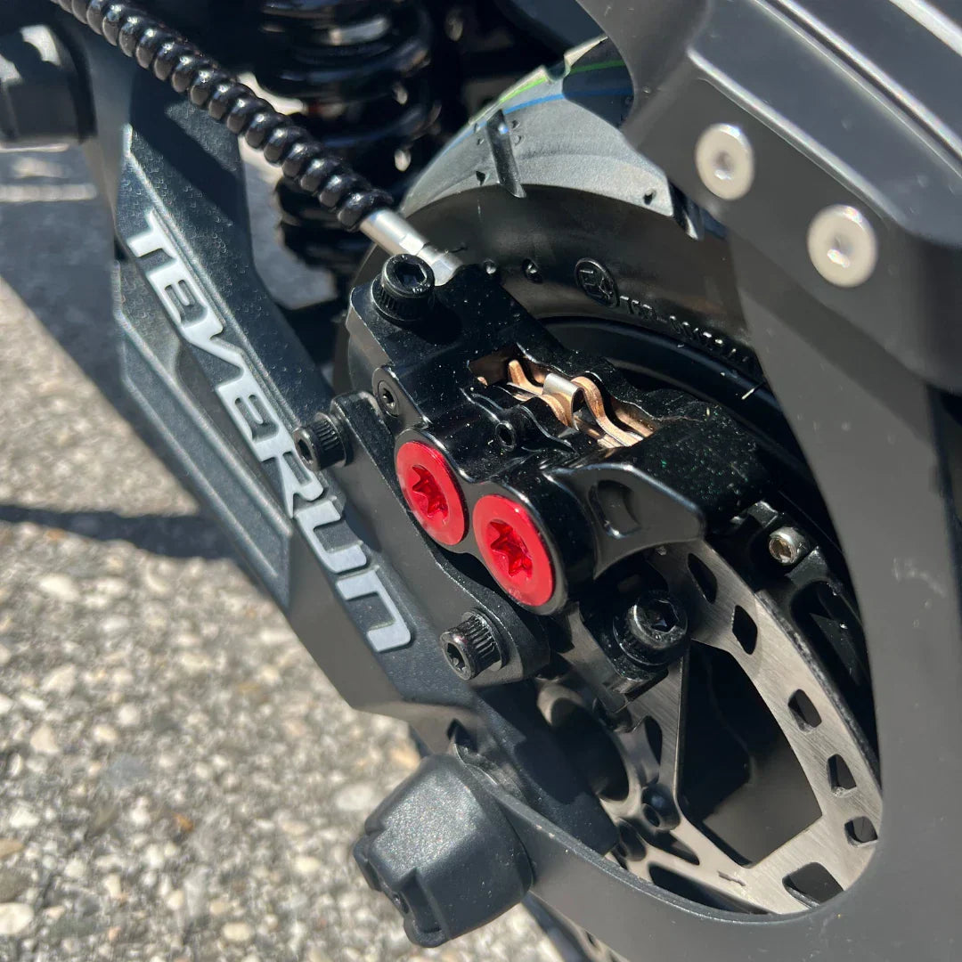 Detaljan prikaz crne kočione čeljusti s crvenim vijcima na električnom romobilu Teverun Fighter Mini