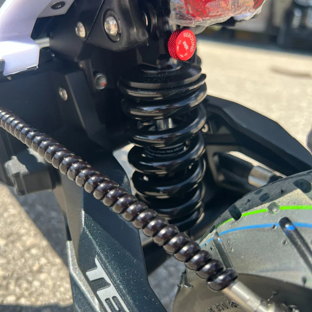Detalj stražnjeg crnog amortizera na električnom romobilu Teverun Fighter Mini Pro 2025