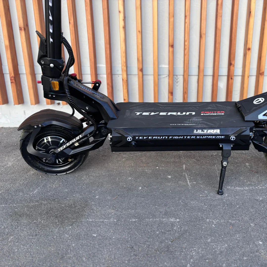 Bočni pogled na crni električni romobil Teverun Fighter Supreme Ultra s detaljima ovjesa i postolja
