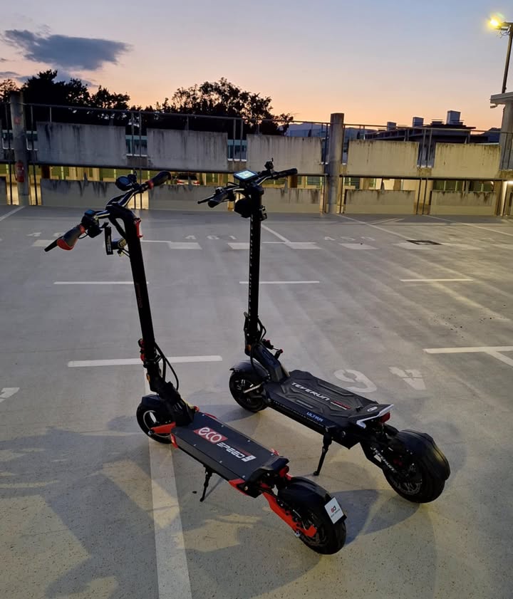 Dva električna romobila Teverun Fighter Supreme i Ultra parkirana na otvorenom u zalazak sunca