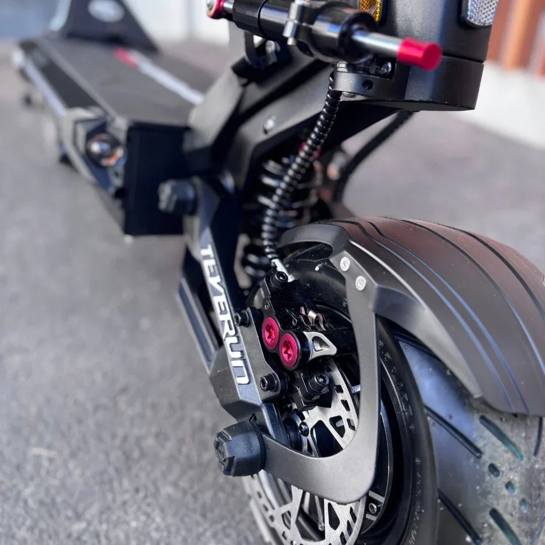 Detalj crnog električnog romobila Teverun Fighter Supreme 7260 Ultra s prikazom ovjesa i kočnice