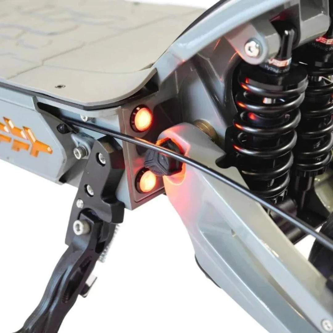 Detalj stražnjeg ovjesa i crvenih svjetala električnog romobila Vsett 11 Plus u sivoj boji