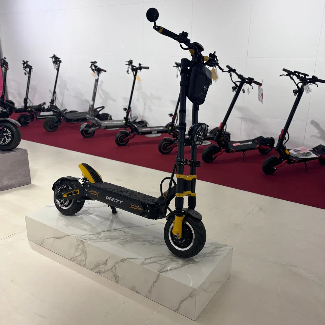 Električni romobil Vsett 11+ Super crno-žute boje izložen na postolju u prodajnom salonu