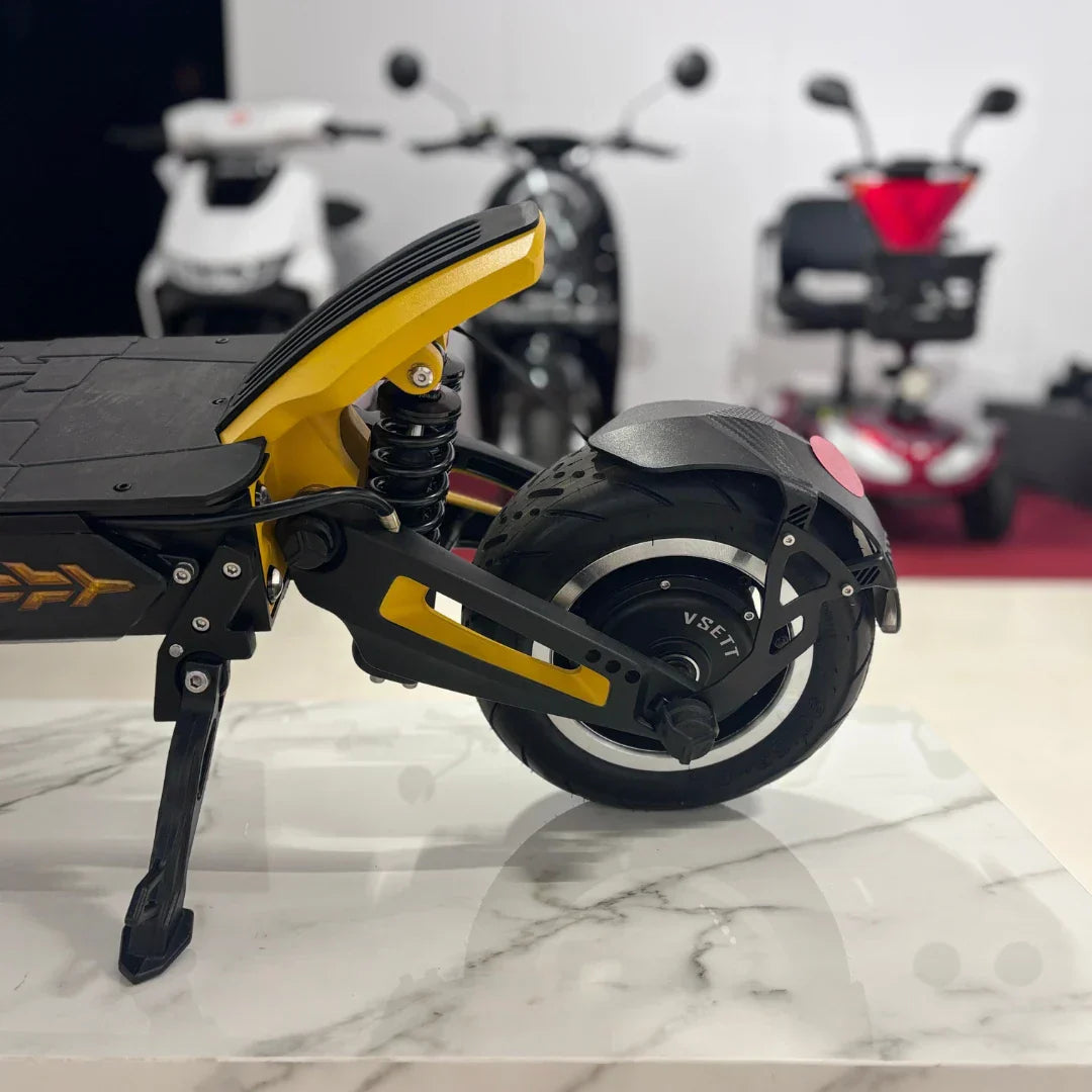 Stražnji dio električnog romobila Vsett 11+ s prikazom ovjesa, kotača i detalja u žutoj boji