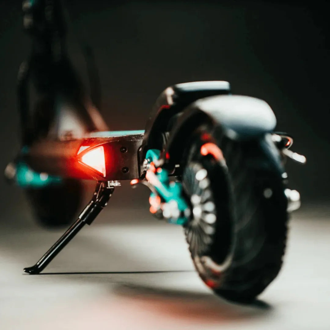 Stražnji dio električnog romobila Vsett 9 i 9 plus s upaljenim crvenim svjetlom i tirkiznim