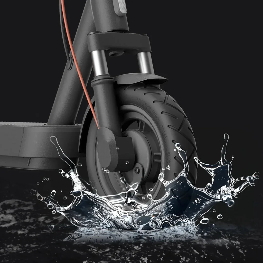 Prednji kotač crnog električnog romobila Xiaomi 5 Max prolazi kroz vodu s prskanjem