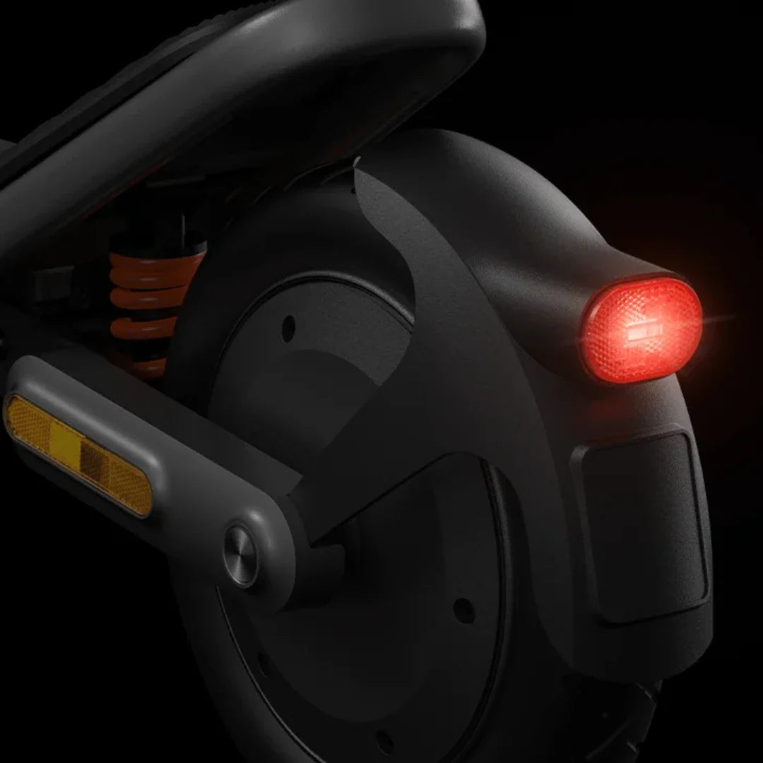 Električni romobil Xiaomi 6 detalj stražnjeg kotača s crvenim svjetlom i narančastim amortizerom