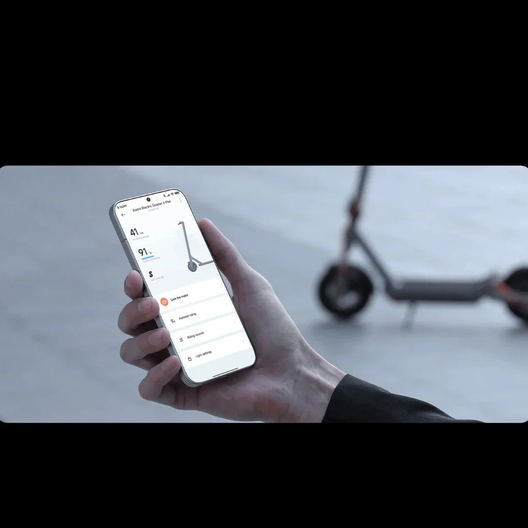 Ruka drži pametni telefon s aplikacijom za električni romobil Xiaomi 6 Max u pozadini