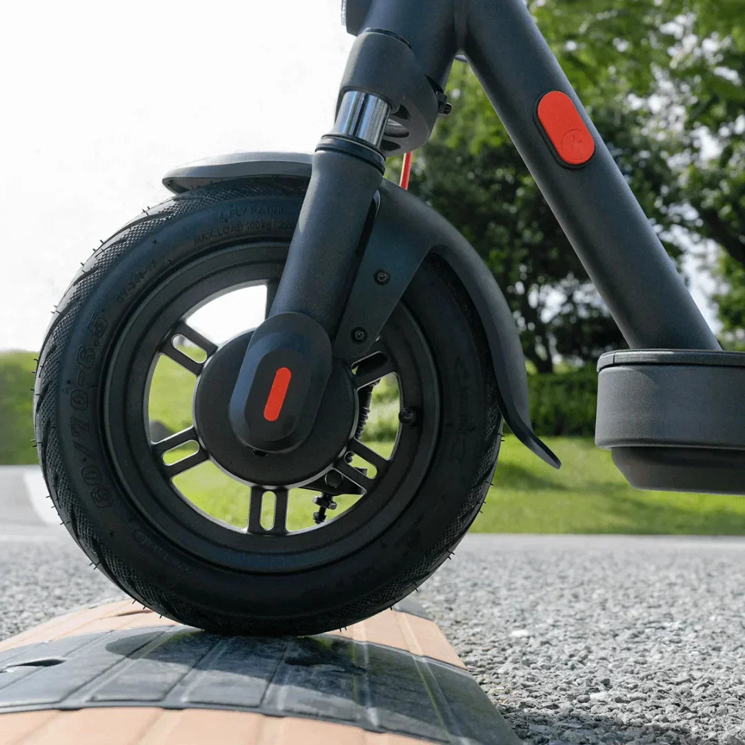 Krupni plan prednjeg kotača i crnog okvira električnog romobila Xiaomi Elite na cesti