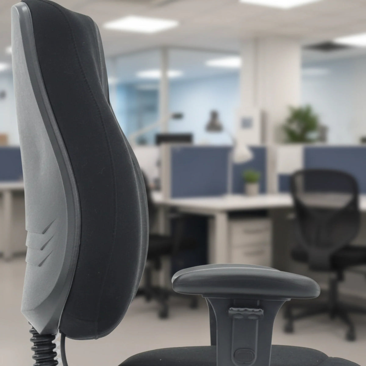 Slika prikazuje ergonomsku uredsku stolicu, točnije model Max Pro. Stolica prikazuje elegantan dizajn s oblikovanim naslonom za leđa i podesivim naslonima za ruke, smještena u modernom uredskom okruženju. Pozadina uključuje radne stanice, naglašavajući njezinu prikladnost za profesionalna okruženja.