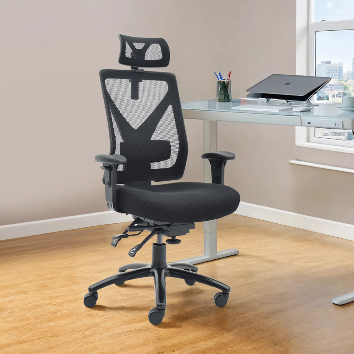 Slika prikazuje ergonomsku uredsku stolicu, točnije model Titan. Ima mrežasti naslon za leđa za prozračnost, podstavljeno sjedalo i podesive naslone za ruke. Stolica je smještena u modernom uredskom okruženju, sa staklenim stolom i prozorom u pozadini, poboljšavajući estetiku radnog prostora.