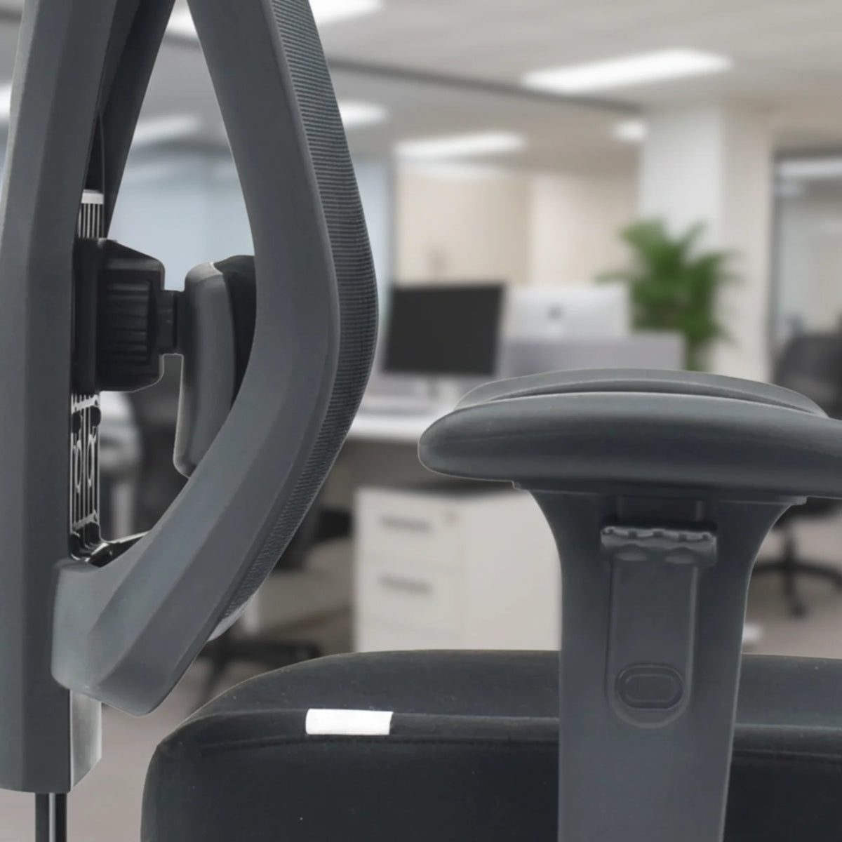 Slika prikazuje ergonomsku uredsku stolicu, točnije model Titan. Prikazuje podesivi naslon za ruke i potporu za leđa na stolici, naglašavajući njezin dizajn namijenjen udobnosti i potpori u profesionalnom okruženju. Pozadina sugerira moderno uredsko okruženje.
