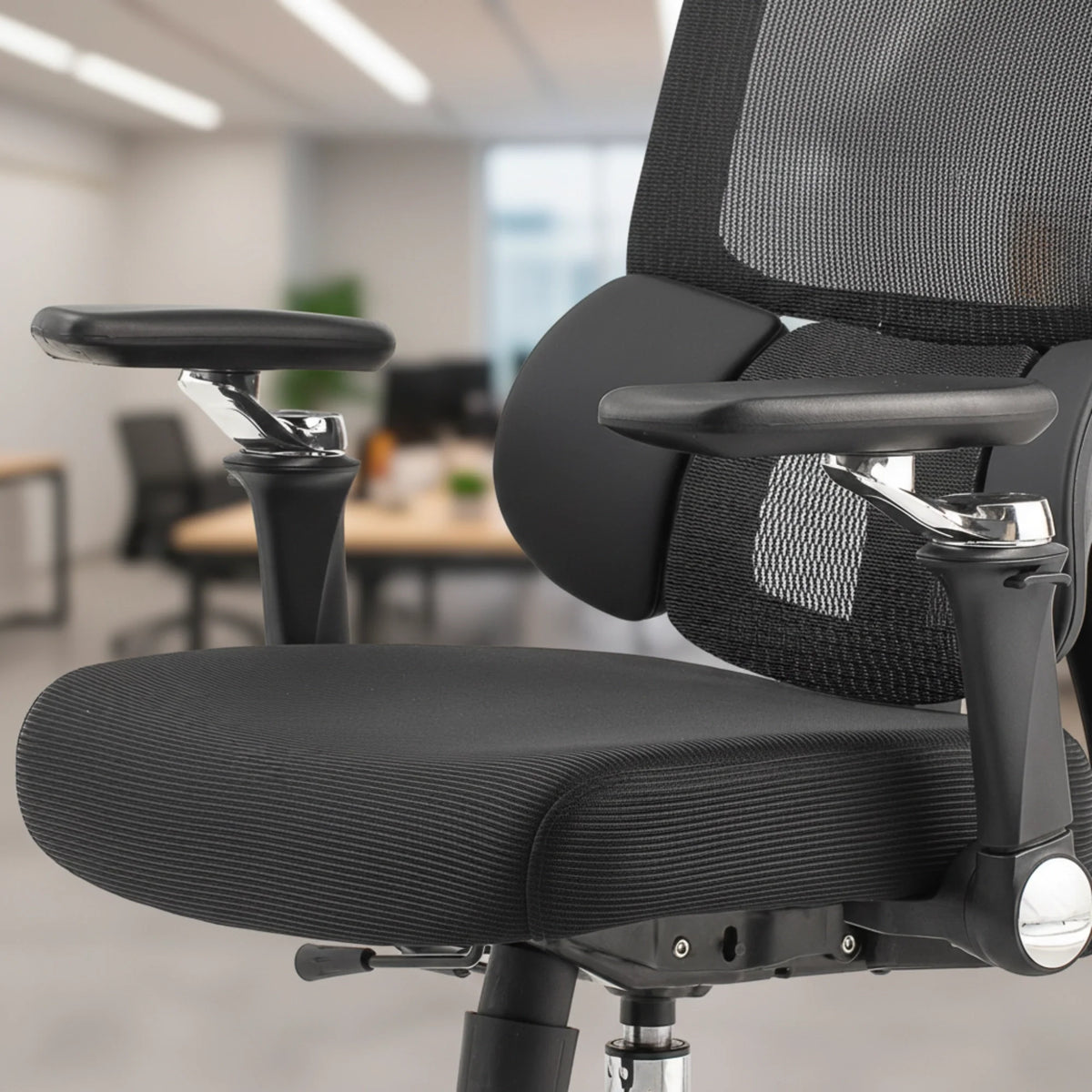 Slika prikazuje ergonomsku uredsku stolicu, točnije model Trek. Prikazuje elegantan dizajn s crnim mrežastim naslonom za leđa i podstavljenim sjedalom. Stolica uključuje podesive naslone za ruke i smještena je u modernom uredskom okruženju, naglašavajući njezinu funkcionalnost i udobnost za duge sate korištenja.