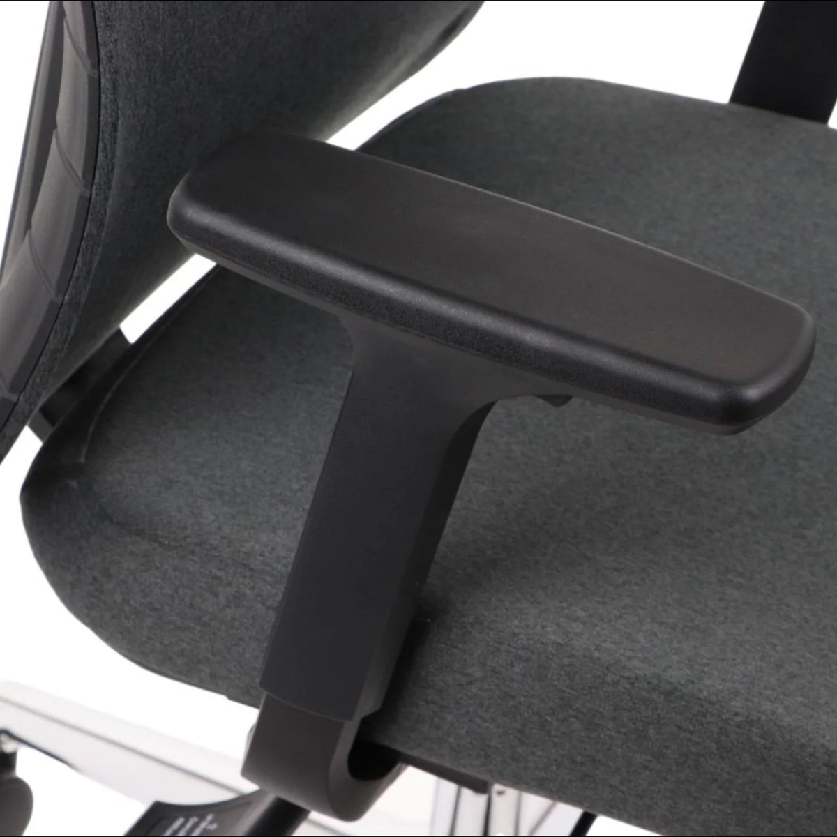 Proizvod je ergonomska uredska stolica, točnije model Akcent. Slika prikazuje krupni plan naslona za ruke stolice, koji je crn i dizajniran za udobnost. Stolica se odlikuje elegantnim dizajnom s presvlakom od sive tkanine, naglašavajući njezinu modernu estetiku.