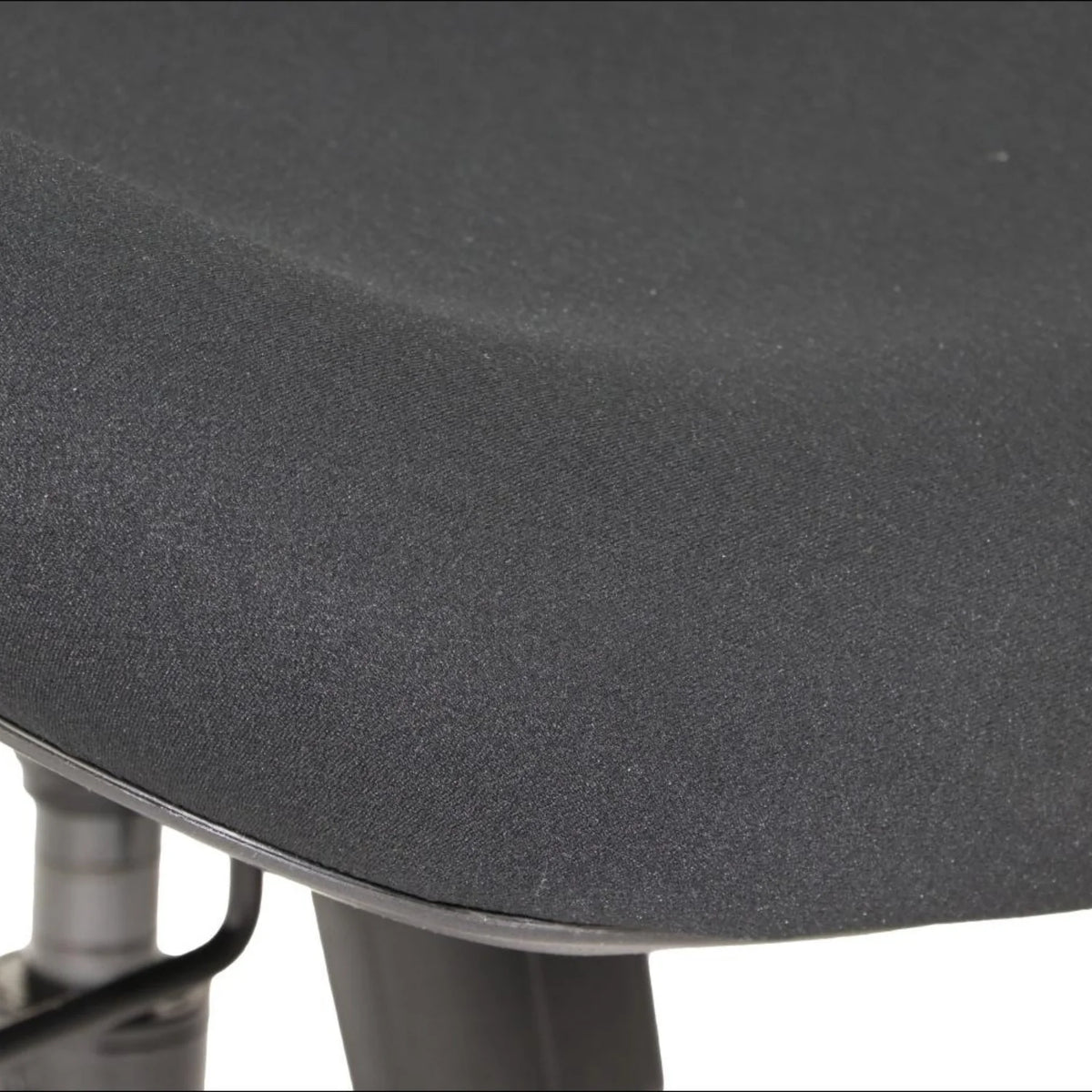 Proizvod je ergonomska uredska stolica, točnije model Arden. Slika prikazuje krupni plan sjedala stolice, koje ima glatku, tamnu površinu od tkanine, naglašavajući njegov udoban dizajn. Baza i mehanizmi stolice također su djelomično vidljivi, što sugerira čvrstu konstrukciju.