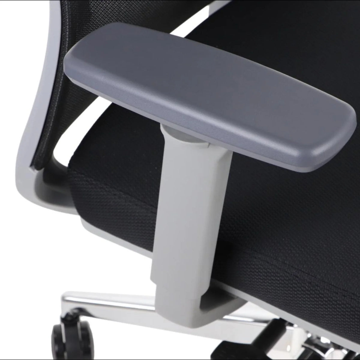 Proizvod je ergonomska uredska stolica, točnije model Cutler GF. Slika prikazuje krupni plan naslona za ruke stolice, koji je sive boje i dizajniran za udobnost, uz teksturirano crno sjedalo i elegantnu kromiranu bazu.