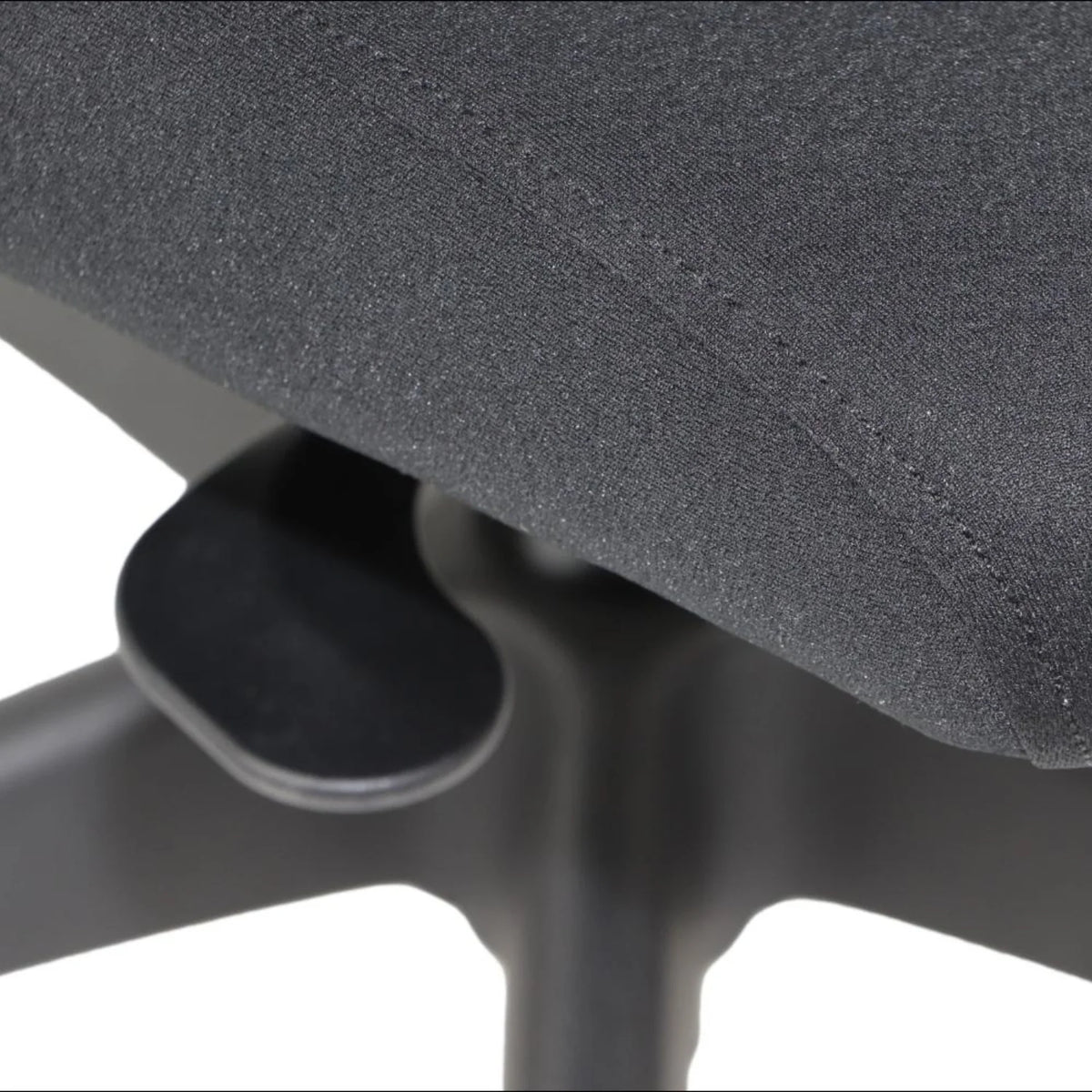 Proizvod je ergonomska uredska stolica, točnije model Morton. Slika prikazuje krupni plan sjedala od tkanine i poluge za podešavanje visine ili nagiba, naglašavajući njezin ergonomski dizajn i funkcionalnost.