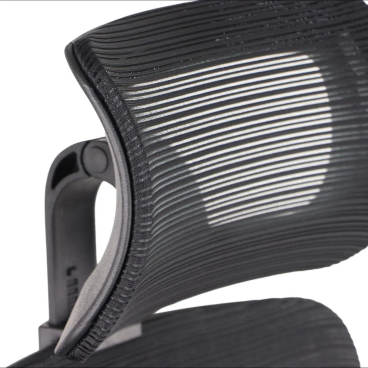 Proizvod je ergonomska uredska stolica, točnije model Wister. Slika prikazuje krupni plan naslona za leđa na stolici, koji ima elegantan, zakrivljen dizajn s vodoravnim utorima, što sugerira fokus na udobnost i potporu. Čini se da je materijal izdržljiva, fleksibilna tkanina koja poboljšava prozračnost.