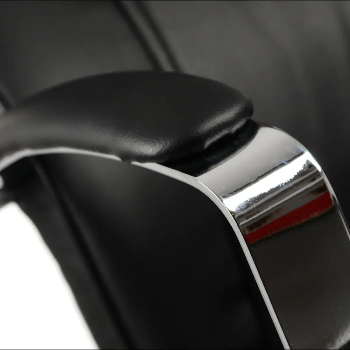 Proizvod je ergonomska uredska stolica, model ZN-9152. Slika prikazuje krupni plan naslona za ruke stolice, koji ima elegantnu crnu podstavu i sjajni kromirani okvir, ističući njezin moderan dizajn i značajke udobnosti.