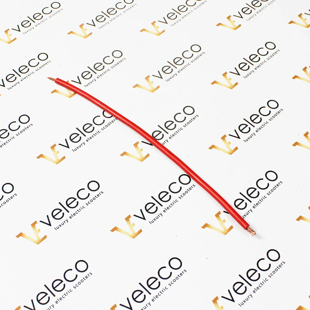 Crveni kabel za napajanje za električni skuter Veleco ZT16 na podlozi s logotipom marke