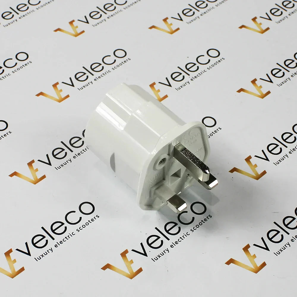 Bijeli univerzalni EU u UK adapter za električna vozila marke Veleco na bijeloj podlozi